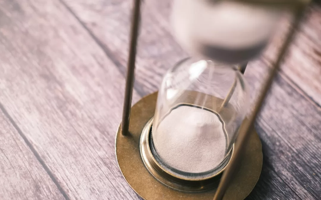 an hourglass sitting on top of a wooden table
