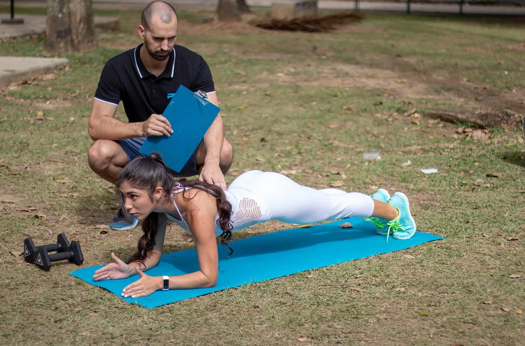 Physiotherapist coaching a plank exercise for trunk extensor endurance